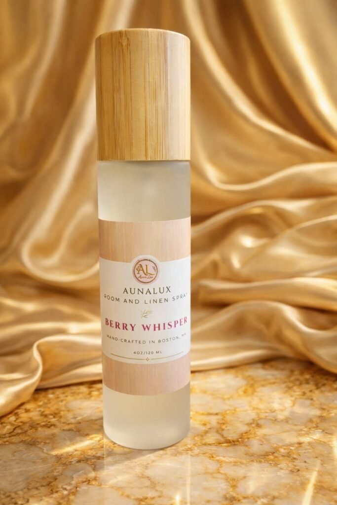 AunaLux Berry Whisper room and linen spray in frosted glass bottle with wooden cap on gold satin background